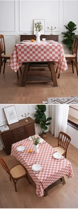 Detail of orange and white checkerboard tablecloth showing natural drape and tight fabric texture
