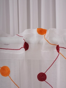 Detail of white sheer café curtain with orange and red 3D circle embroidery texture
