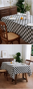 Detail of green and white checkered cotton linen tablecloth on a wooden dining table