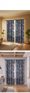 Détail de rideaux floraux bleu foncé avec franges à pompons blancs dans un salon chic