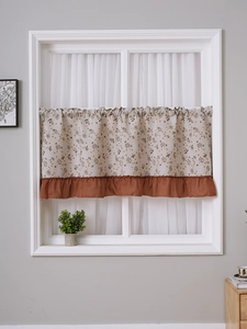 Detail of floral cafe curtain with ruffled hem and vintage American country pattern