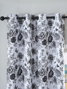 Detail of white blackout curtain with black floral pattern and silver metal eyelets