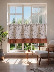 Detail of floral cafe curtain with ruffled hem in a bright modern farmhouse interior