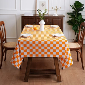 Minimalist orange and white checkered tablecloth on a rectangular wooden dining table