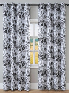 Detailed close-up of white blackout curtains with black floral print and metal grommets