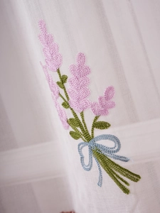Close-up of lavender floral embroidery on white sheer cafe curtain for kitchen