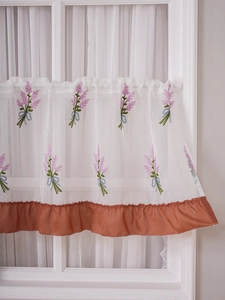 Detail of lavender embroidery on white sheer cafe curtain with a brown ruffled edge trim