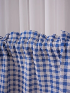 Detail of blue and white checkered fabric with visible woven texture and natural folds