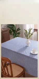 Detailed close-up of blue and white checkered tablecloth texture on a wooden dining table