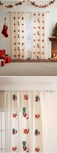 Detail view of Christmas embroidery on beige lace curtain with Santa Claus and sled patterns