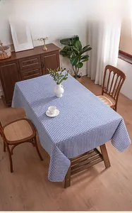 Detailed top view of blue checkered tablecloth with frayed edges on a wooden table