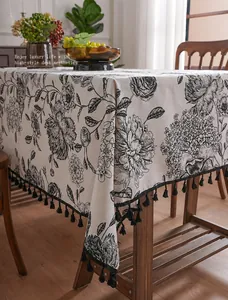 Detailed texture of linen tablecloth with vintage floral prints and black tassel fringe