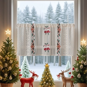 Christmas lace cafe curtain with bell and stocking embroidery in a festive snowy window