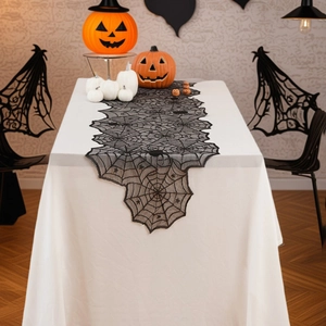 Black lace spider web table runner for Halloween party decor on a wooden table
