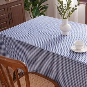 Blue and white checkered tablecloth with a rustic linen texture on a wooden table