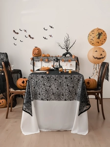 Detailed view of black lace spider web tablecloth for Halloween haunted house table decor