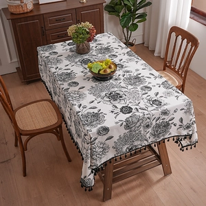 French vintage floral linen tablecloth with elegant black tassels on wood table