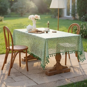 French vintage pale green lace tablecloth with elegant fringe in a garden setting