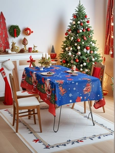 Close-up of a blue Christmas tablecloth with Santa, reindeer patterns, and red border
