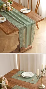 Detailed sage green lace table runner and placemat set with floral embroidery on wood table
