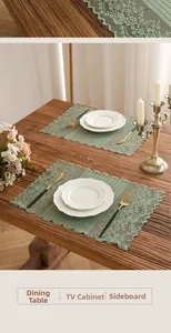 Detail of sage green lace table runner with floral embroidery on rustic wooden furniture