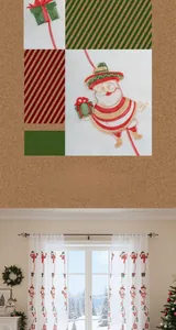 Detail of Santa Claus and Navidad embroidery on white translucent Christmas window curtains