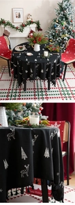 Detail of round black Christmas tablecloth with white elk embroidery and elegant fringe edge