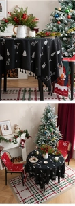 Detail of Christmas tablecloth with white deer and tree patterns and black tassels
