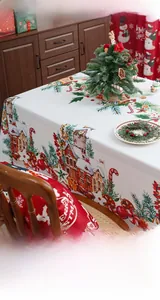 Detailed Christmas tablecloth showing snowy house prints and festive pine branch patterns