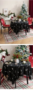 Detailed close-up of a black Christmas tablecloth with white elk pattern and tassel edge