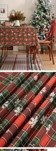 Close-up of festive red and green plaid Christmas tablecloth with white snowflake patterns