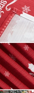 Detail of red Christmas tablecloth with snowflake prints and fine stitching at the edges