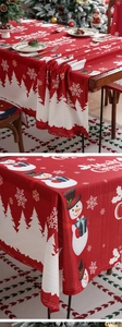 Detailed close-up of red Christmas tablecloth featuring snowmen and Merry Christmas text