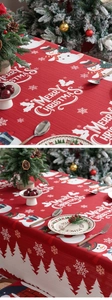 Close-up of Christmas tablecloth featuring red festive prints with snowmen and fir trees