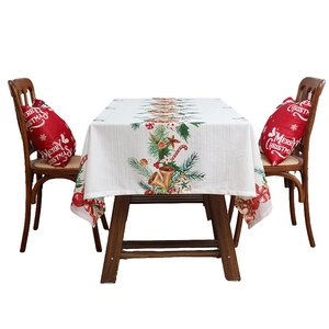 Christmas tablecloth with golden bells and pine branches on a wooden dining table