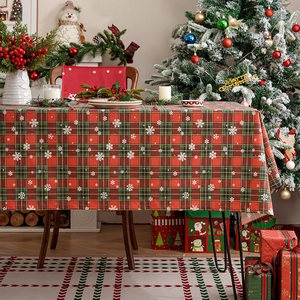 Red and green plaid Christmas tablecloth with snowflake patterns in a festive setting