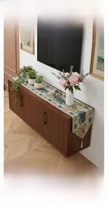 Close-up of vintage flower and bird pattern table runner with elegant white tassels