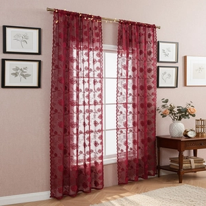 Detail of burgundy lace curtain with floral embroidery and elegant scalloped edges