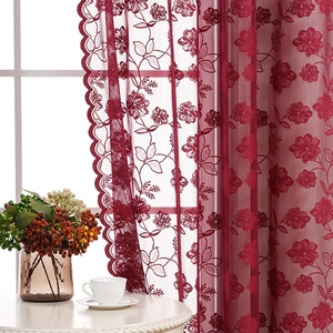 Detailed embroidery of wine red floral patterns on translucent white lace curtains