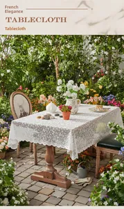 Detailed macro view of elegant white floral hollow lace tablecloth with wavy edges