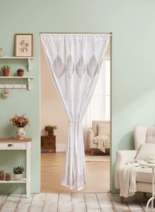 Detail of semi-transparent lace door curtain with grey feather patterns in home setting