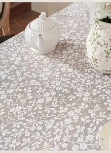 Macro shot of white hollow lace tablecloth with vintage floral pattern texture