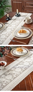 Close-up of white lace table runner featuring intricate peacock and floral embroidery