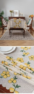 Detail of floral embroidery and lace edging on beige fabric for dining table decor