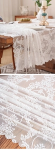 Macro shot of white vintage floral lace tablecloth with elegant scalloped wavy edges