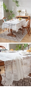 Macro detail of white floral lace tablecloth showing intricate embroidery and scalloped edges