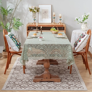 Elegant light green lace tablecloth with vintage floral embroidery on rectangular wood table