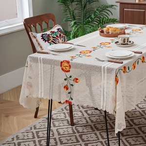 Rectangle cream lace tablecloth with red and yellow rose embroidery in a dining setting