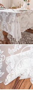 Detailed view of white lace tablecloth featuring Baroque patterns and elegant wavy edges