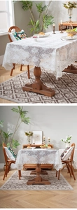 Close-up of white lace tablecloth with detailed floral crochet patterns and wavy edges